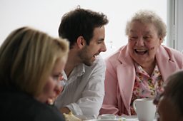 Elderly woman chatting to a man