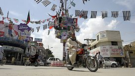 Man passing Pakistan election posters