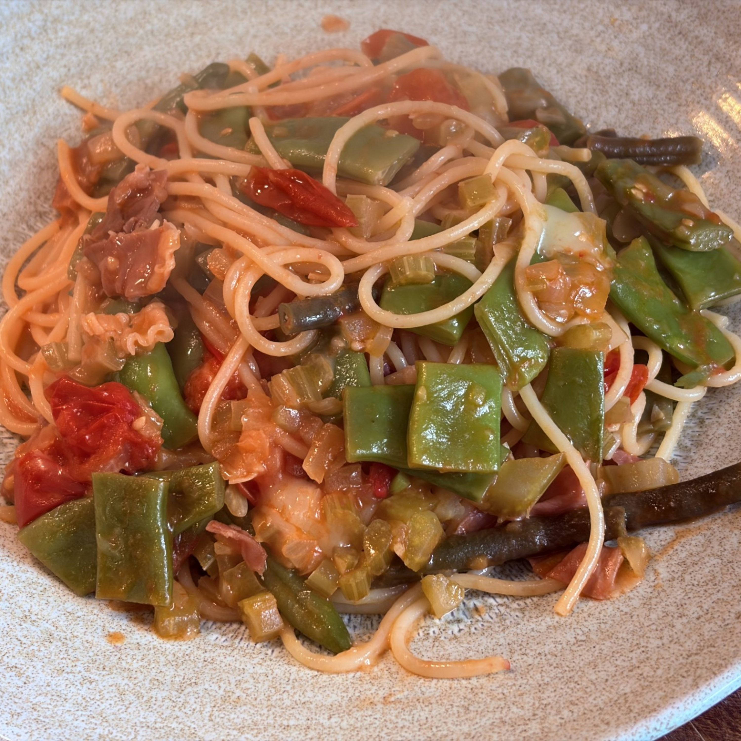 Braised local beans with parma ham and spaghetti
