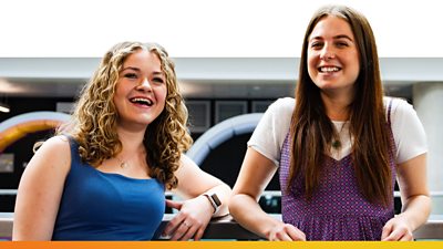 Two Ģ������Ƶ colleagues smiling and leaning on a railing