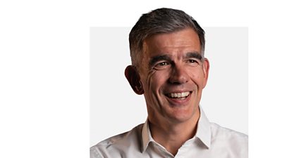 Director General Matt Brittin smiles, looking into the middle distance. He is wearing a white shirt.