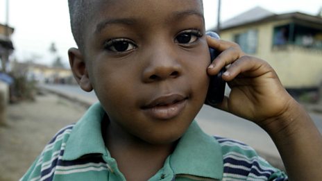 A young boy listening to the radio