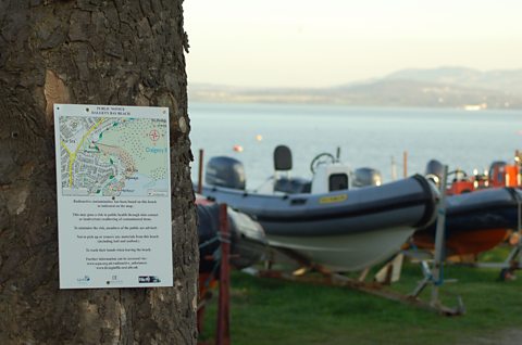 A sign on a tree next to Dalgety Bay sailing club informs the public of radioactive finds