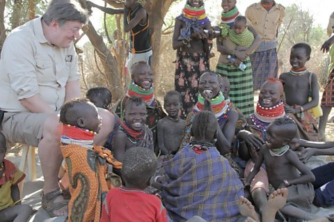 Stephen Fry sitting with the Turkana Tribe