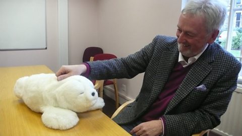 Dr George Leeson, of the Oxford Institute of Ageing with the Paro therapeutic seal robot