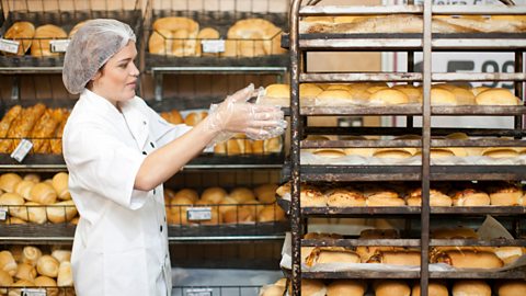 Lady stacking bread