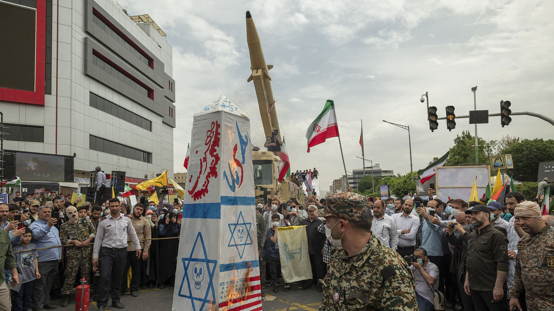  An Islamic Revolutionary Guard Corps (IRGC) personnel looks at the US and Israeli flags burning in front of an Iranian Kheibar Shekan Ballistic missile in Tehran (Credit: Morteza Nikoubazl/Getty Images)