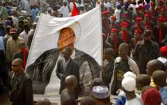 Black-shirted followers of a hardline Shiite Muslim sect carry a banner depicting Ibrahim Zakzaky, a Nigerian Shiite radical who wants to set up an Islamic Republic, as thousands of Nigerian Muslims protest 10 February, 2005 in the northern city of Kano