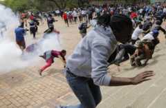 Students from Wits University are thrown to the ground after a stun grenade exploded near them during running battles on the campus as ongoing protests continue against the cost of higher education in Johannesburg, South Africa, 04 October 2016