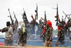 Fighters with the Movement for the Emancipation of the Niger Delta (MEND) raise their riffles to celebrate news of a successful operation by their colleagues against the Nigerian army in the Niger Delta on September 17, 2008.