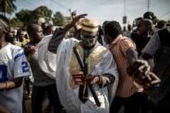 02/12/2016 AFP/Getty Images A man dressed like incumbent president Yahya Jammeh (C) parades with supporters of the newly elected president Adama Barrow as they celebrate his victory during the presidential elections in Serekunda on December 2, 2016.
