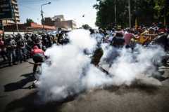 A stun grenade thrown by South African police forces ricochet on a student taking part in a protest in Johannesburg on September 21, 2016.