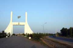 A car drives past the city gate to Abuja