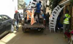 Des hommes déchargent des chaises devant l'ambassade de la Gambie à Dakar