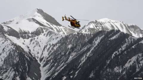 A rescue helicopter flies over the French Alps during a operation after the crash of an Airbus A320