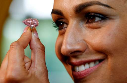 A model poses with the "Unique Pink", a 15.38 carats vivid pink diamond, at Sotheby"s auction house in Geneva, Switzerland May 9, 2016.