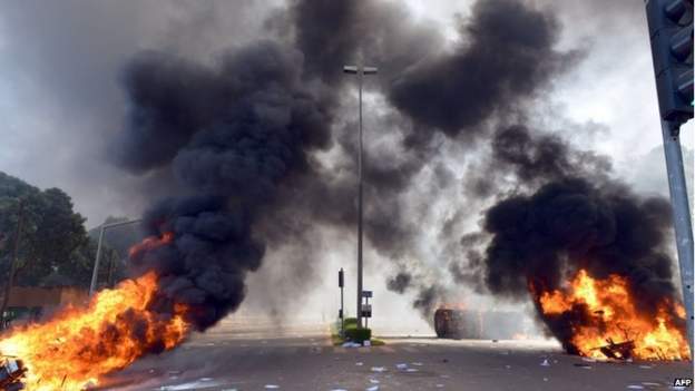 Cars and documents burn outside the parliament in Ouagadougou on 30 October 2014.