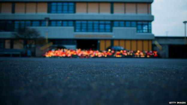 A memorial of flowers and candles in front of the Joseph Koenig secondary school