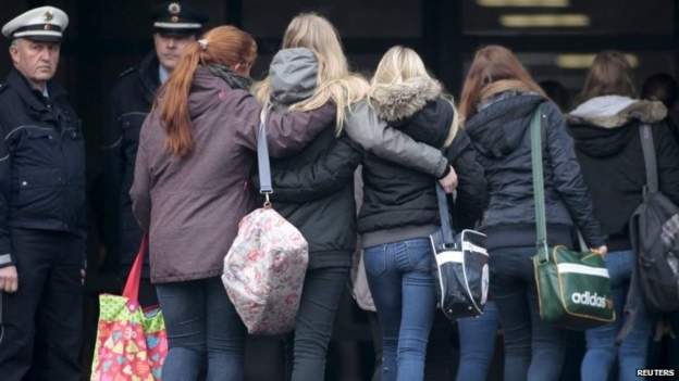 Students hold onto each other as they arrive at the Joseph-Koenig-Gymnasium high school in Haltern am See