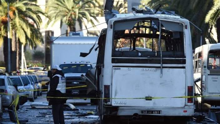 Tunisian forensic police inspect the wreckage of a bus in the aftermath of a bomb attack on the vehicle which was transporting Tunisia"s presidential guard in central Tunis on November 25, 2015.