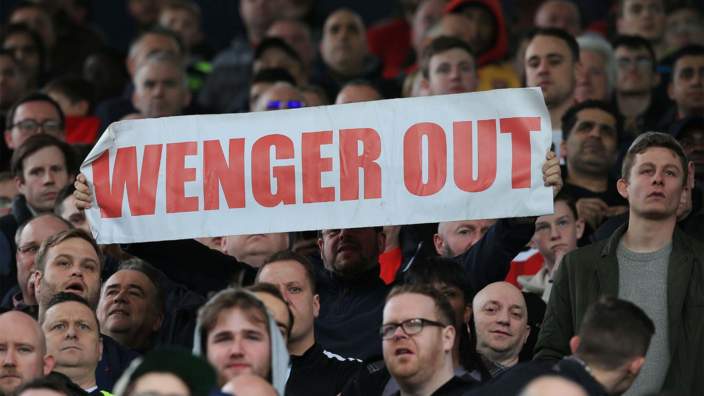 An Arsenal fan with a 'Wenger Out' banner