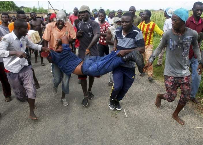 Protesters carry a female police officer accused of shooting a protestor in the Buterere neighbourhood of Bujumbura, Burundi, May 12, 2015.