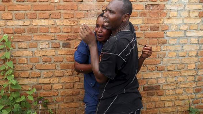 A man tries to protect a female police officer accused of shooting a protestor from other protesters in the Buterere neighbourhood of Bujumbura, Burundi, May 12, 2015.