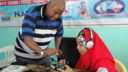 A man showing a woman how to use recording equipment