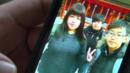 Close up of woman's hand holding smartphone with photo of her son and daughter who died in a fire at a water park concert in Taiwan