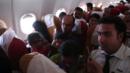 Children sitting on adults laps on board the plane