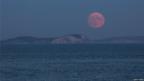 Large full moon over an island