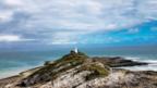 Lighthouse under cloudy skies