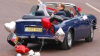 William and Kate leave Buckingham Palace in Prince Charles' vintage Aston Martin.