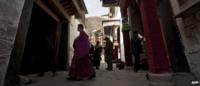 Tibetan monk walks past pilgrims at the Labrang monastery in Xiahe, Gansu province, file image