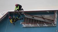 Rescue workers attempt to board the stricken Costa Concordia