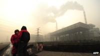 Two people talking outside coal-fired power plant in Linfen, Shanxi province.