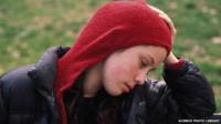 Worried girl sitting on a park bench