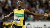 Usain Bolt sprinting in a yellow vest. His arms are stretched out to his sides in celebration.