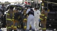 Firefighters remove the wreckage of a car