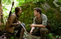 Jennifer Lawrence as Katniss Everdeen and Liam Hemsworth as Gale Hawthorne