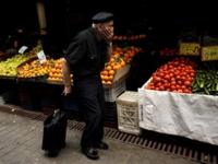 Greek man walking past market