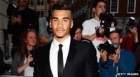 Gymnast Louis Smith wearing a suit and posing for cameras