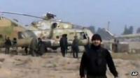 Screengrab of video published by opposition activists purportedly showing rebel fighter standing near helicopters at an airbase near Damascus (25 November 2012)