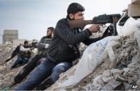 Syrian rebel fighters take aim near the Damascus-Aleppo highway in Maarat al-Numan (17 November 2012)