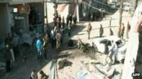 An image grab taken from the state-run Syrian TV shows Syrians inspecting destruction following a car bomb blast in the town of Qatana, southwest of Damascus