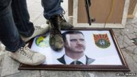 Syrian rebels stand on a picture of President Bashar al-Assad (20 August 2012)