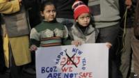 Young Indian girls hold a placard as they participate in a protest in Delhi on 31 Dec 2012