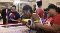 A woman weeps beside the coffin of Hugo Chavez