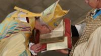 Archbishop Justin Welby kisses the book