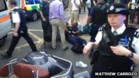 Police, medics and passers-by around a man who came off a moped